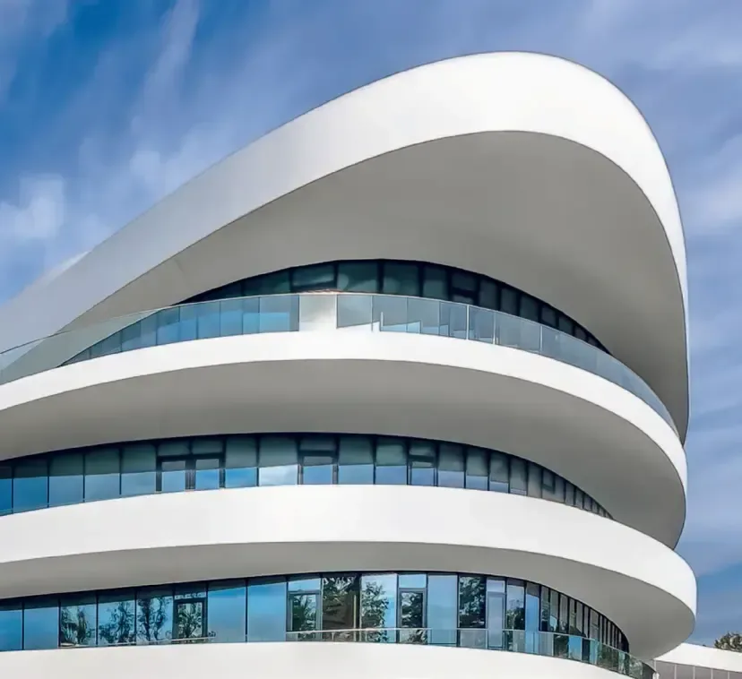Bâtiment contemporain aux balcons courbes avec garde-corps vitrés — aménagement aluminium et verre — ALU-CO & Vitralux Luxembourg