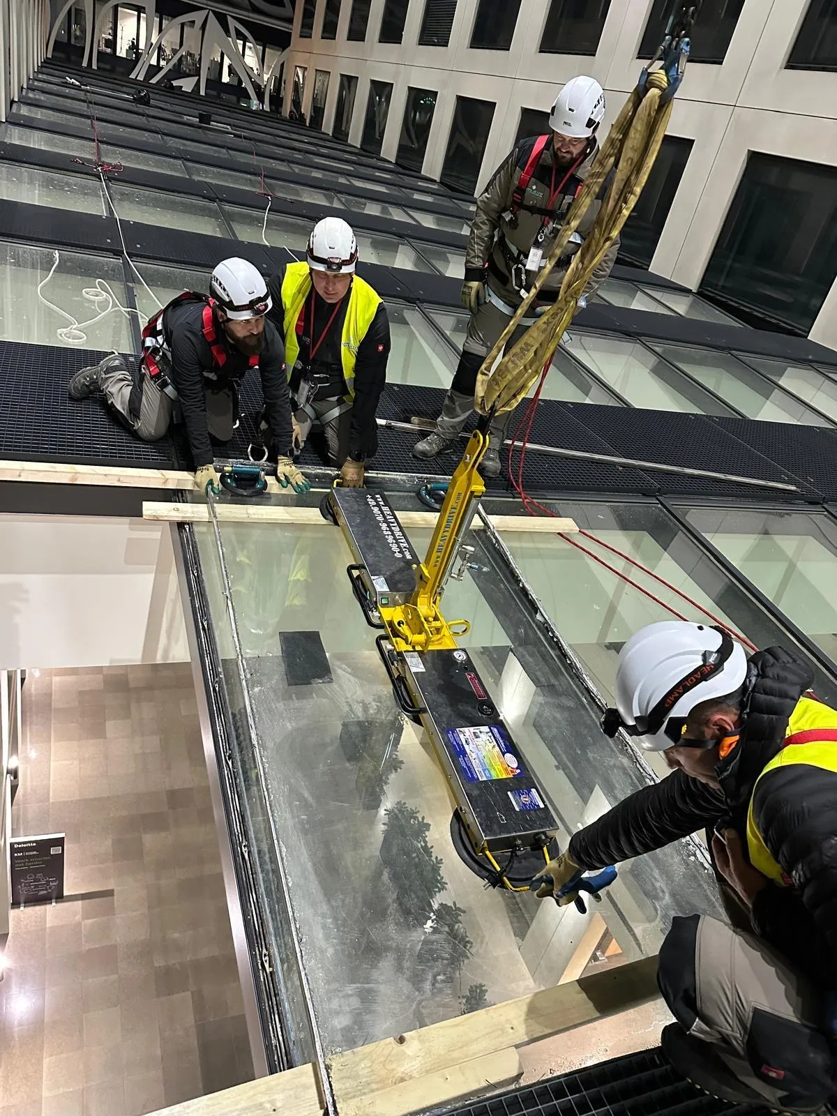 Remplacement nocturne de vitrages de toiture à accès difficile chez Deloitte Kirchberg — grue Liebherr, lève-verre motorisé et techniciens en harnais — réparation de vitrages Luxembourg — Vitralux Bradtke (photo 1)