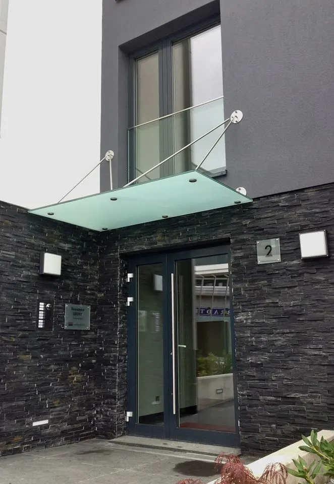 Auvent en verre dépoli au-dessus d'une porte d'entrée en pierre — Résidence Ebony — Vitralux Bradtke
