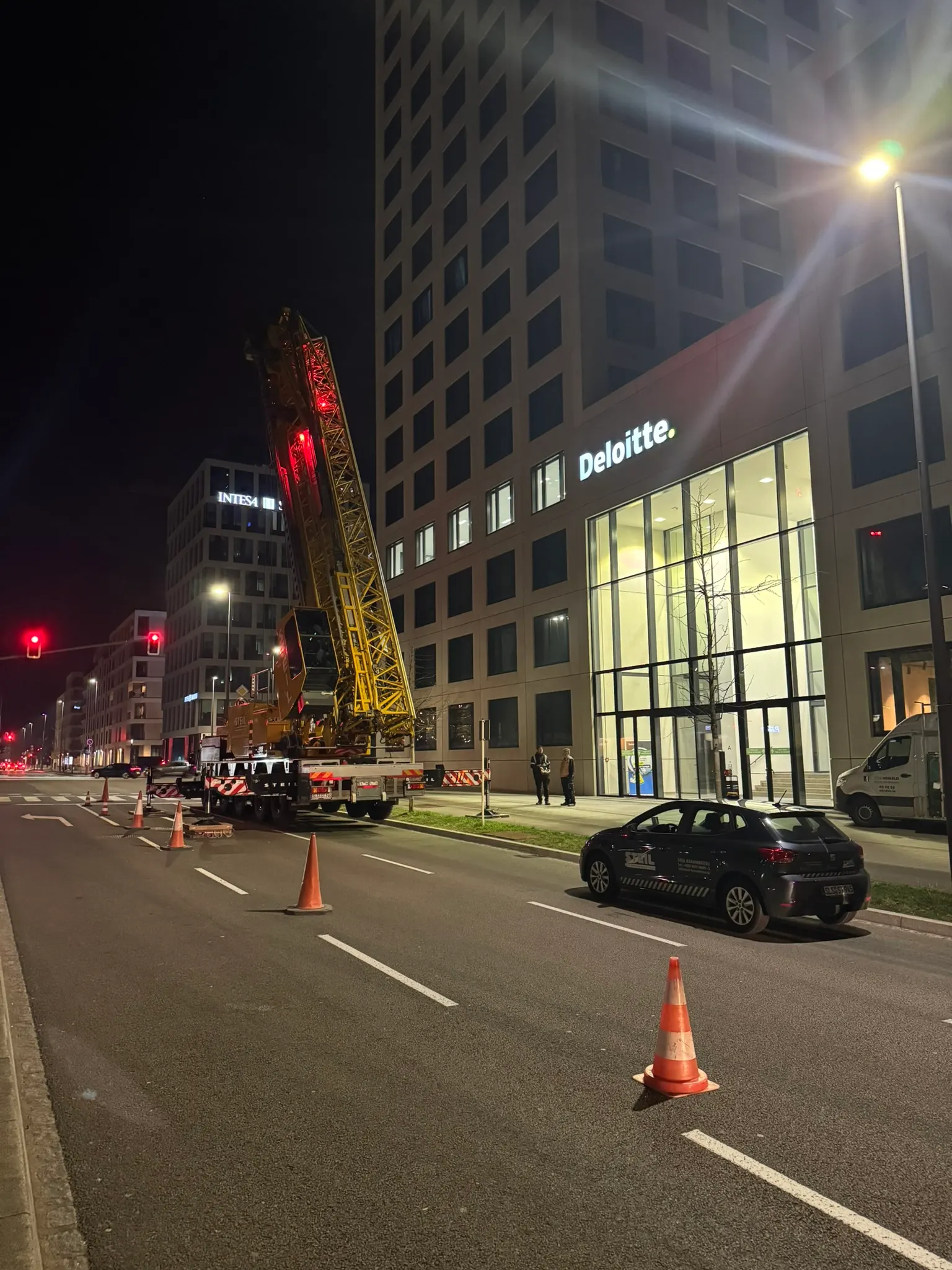 Grue de levage sur un chantier vitré en centre-ville la nuit — intervention technique Vitralux — Luxembourg