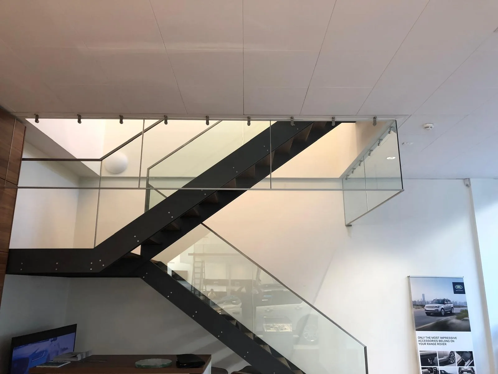 Détail de fixation inox d'un écran de cantonnement de fumée en verre — Vitralux Bradtke Luxembourg
