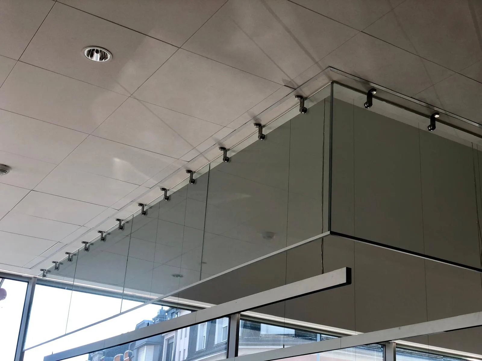 Panneaux verticaux d'un écran de cantonnement de fumée en verre suspendus sous plafond — désenfumage verre Luxembourg — Vitralux Bradtke