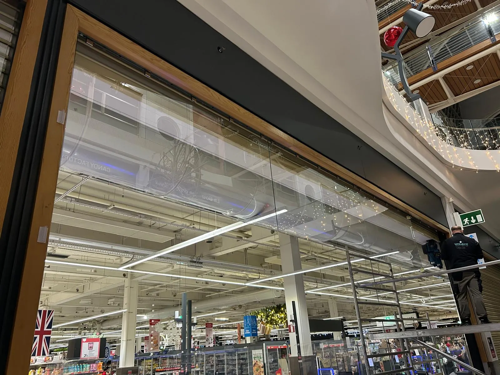 Grand écran de cantonnement vitré en façade intérieure d'un hypermarché — Vitralux Bradtke