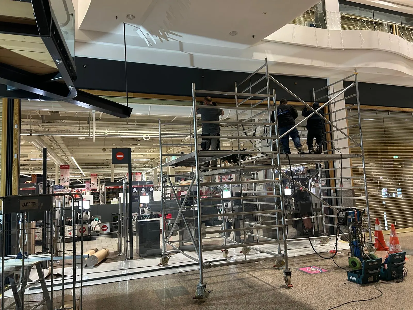 Pose nocturne d'un écran de cantonnement de fumée en verre dans une galerie commerciale — Vitralux Bradtke Luxembourg