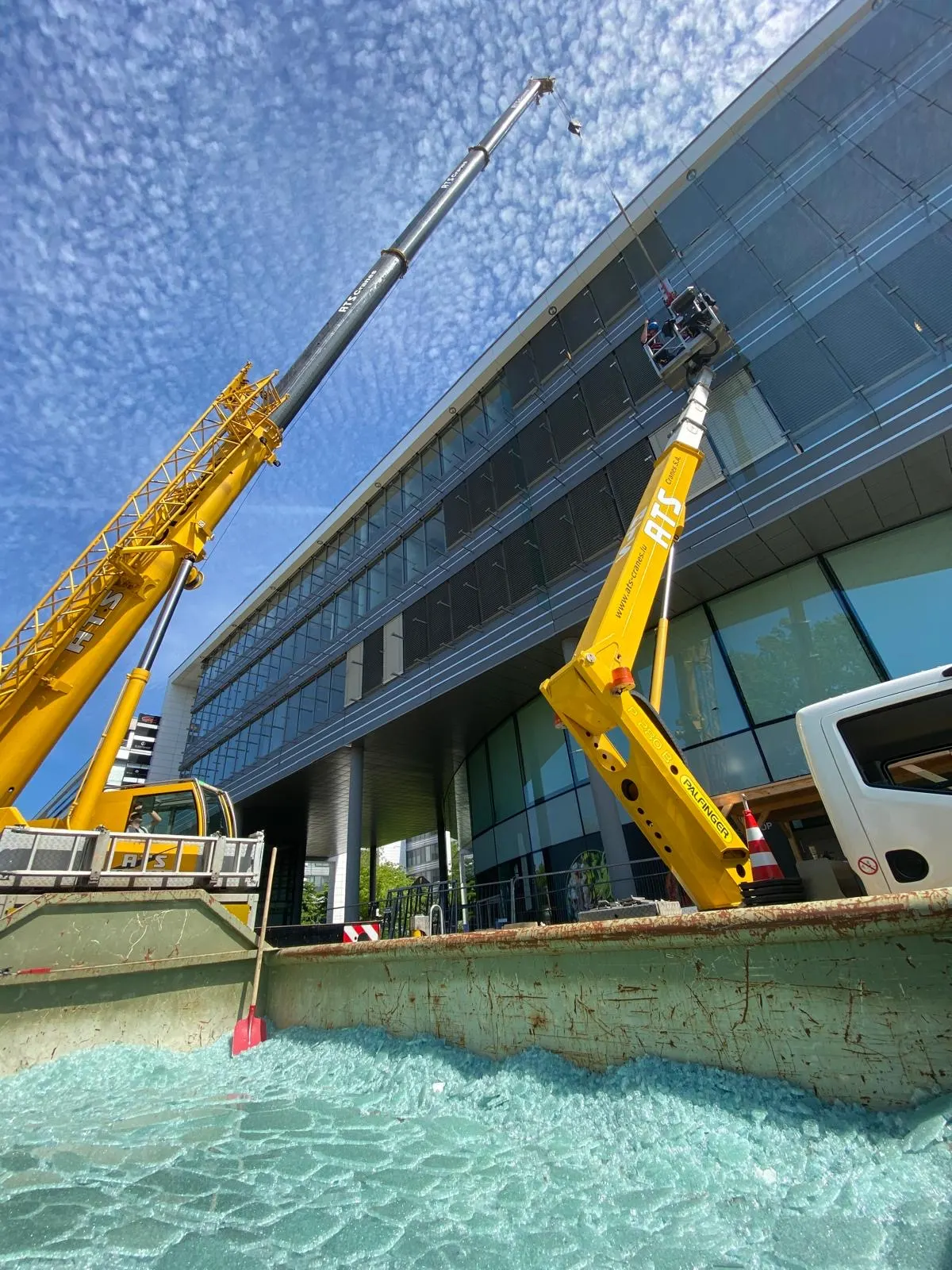 Grue et nacelle élévatrice sur un chantier de façade vitrée en milieu urbain — Luxembourg — Vitralux Bradtke