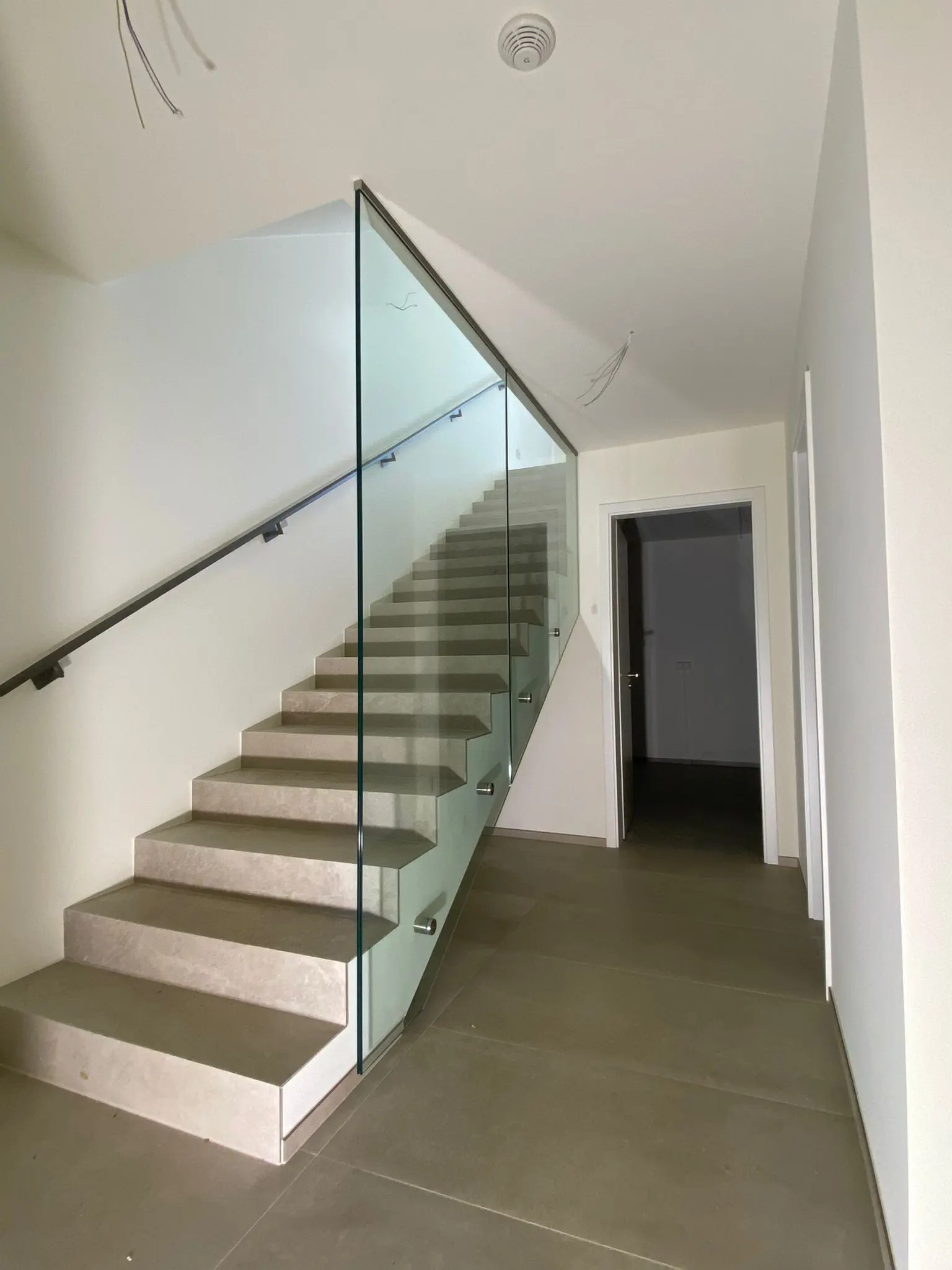 Garde-corps en verre sur attaches ponctuelles inox le long d'un escalier intérieur — Vitralux Bradtke Luxembourg