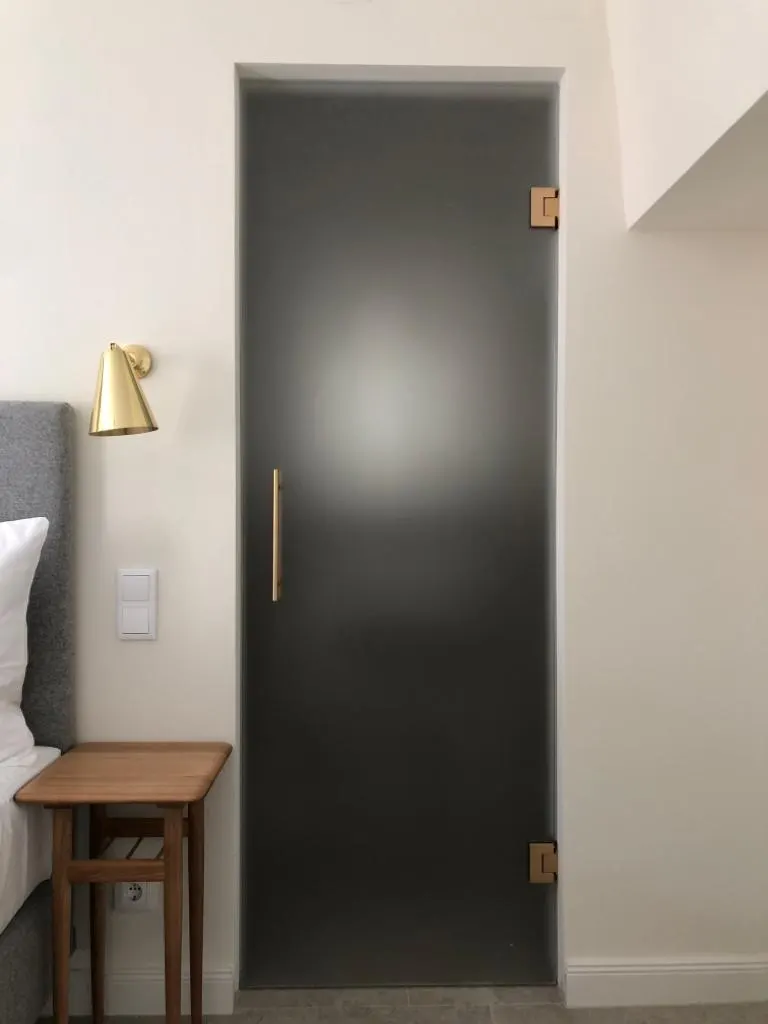 Porte sur charnière mur-verre finition dorée — Vitralux Bradtke Luxembourg