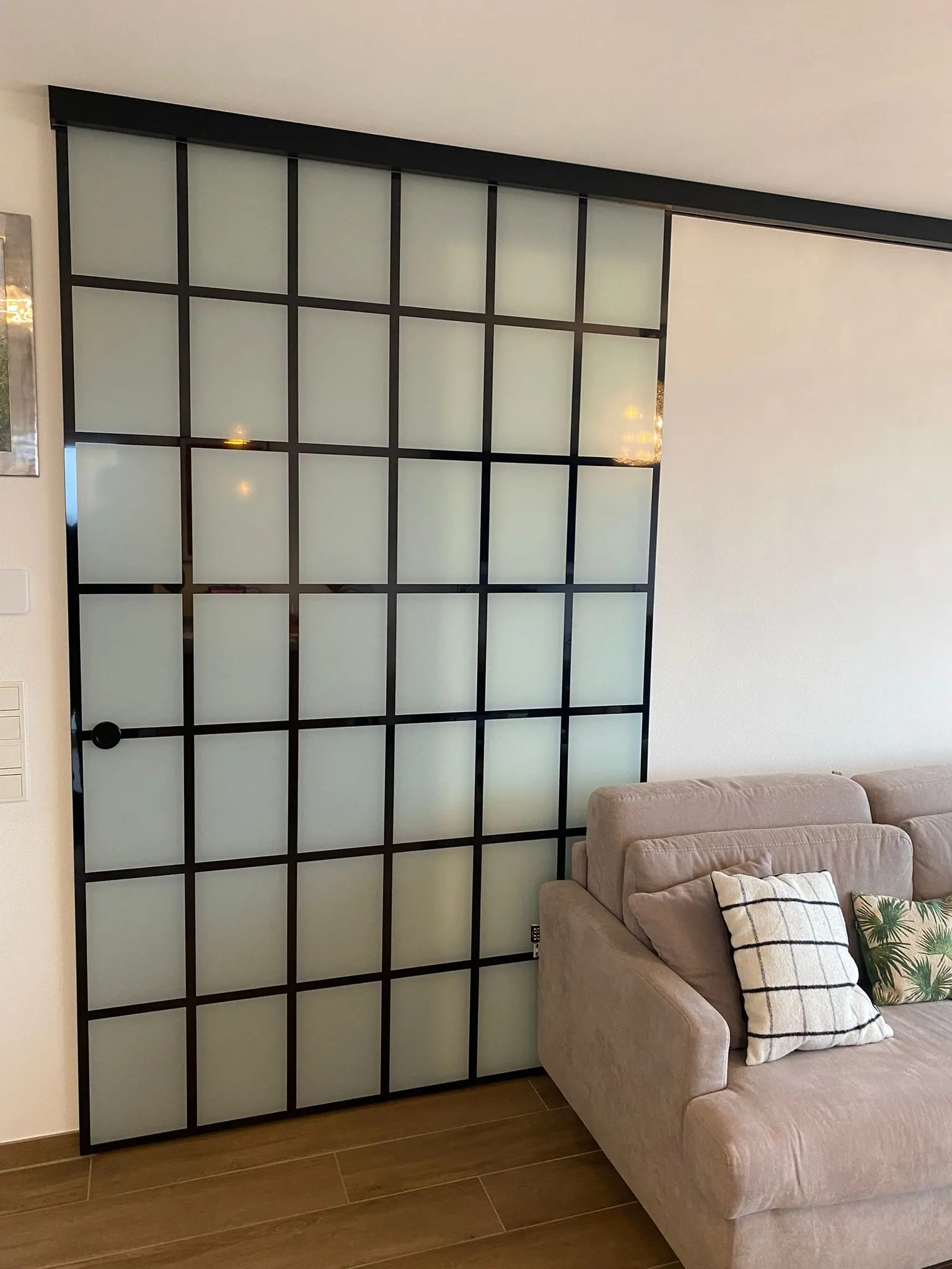 Paroi coulissante style verrière en verre satiné et grille noire dans un séjour — verrière intérieure Luxembourg — Vitralux Bradtke
