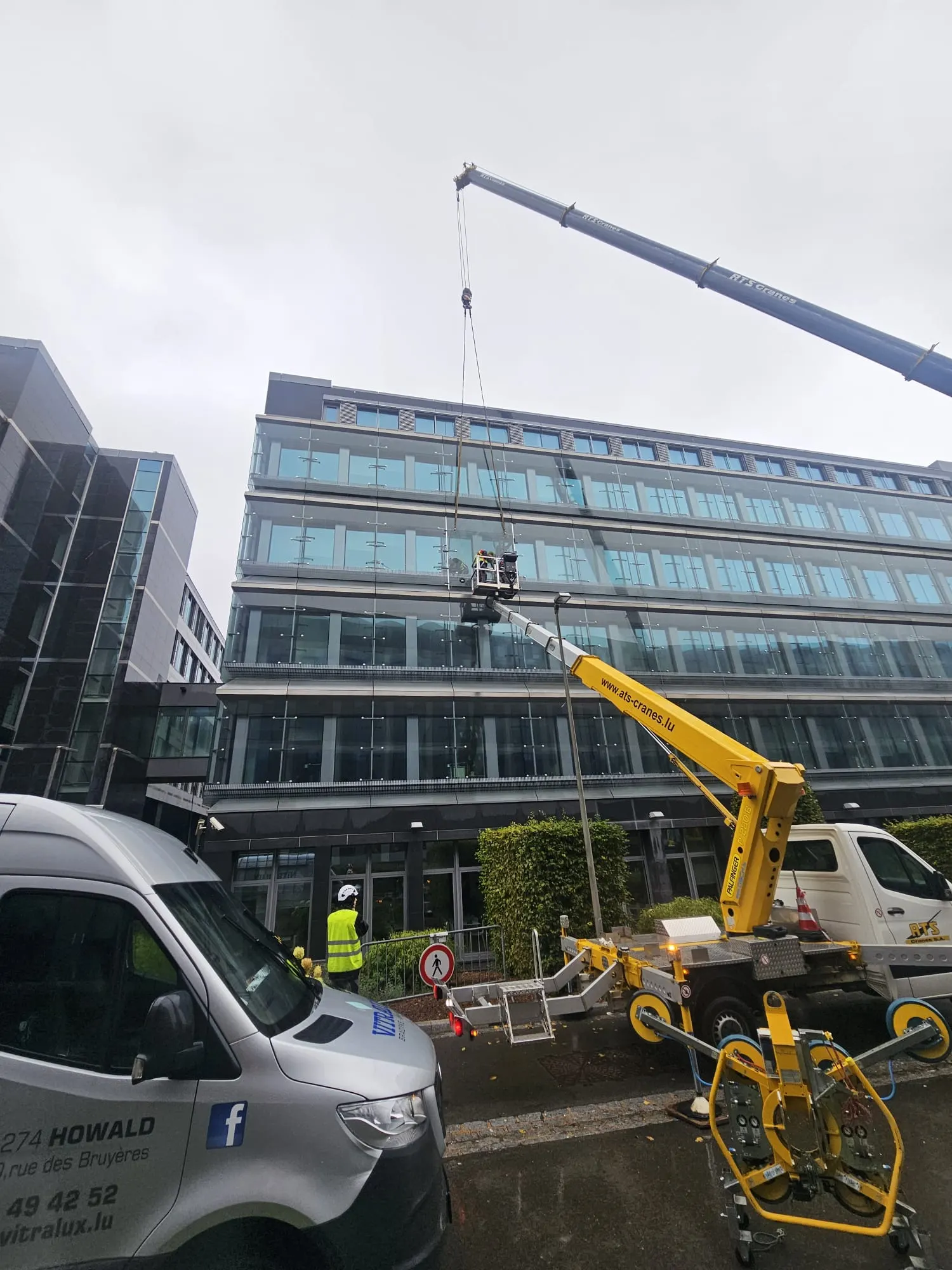 Grue mobile déployée devant un immeuble de bureaux pour un vitrage en hauteur — Vitralux