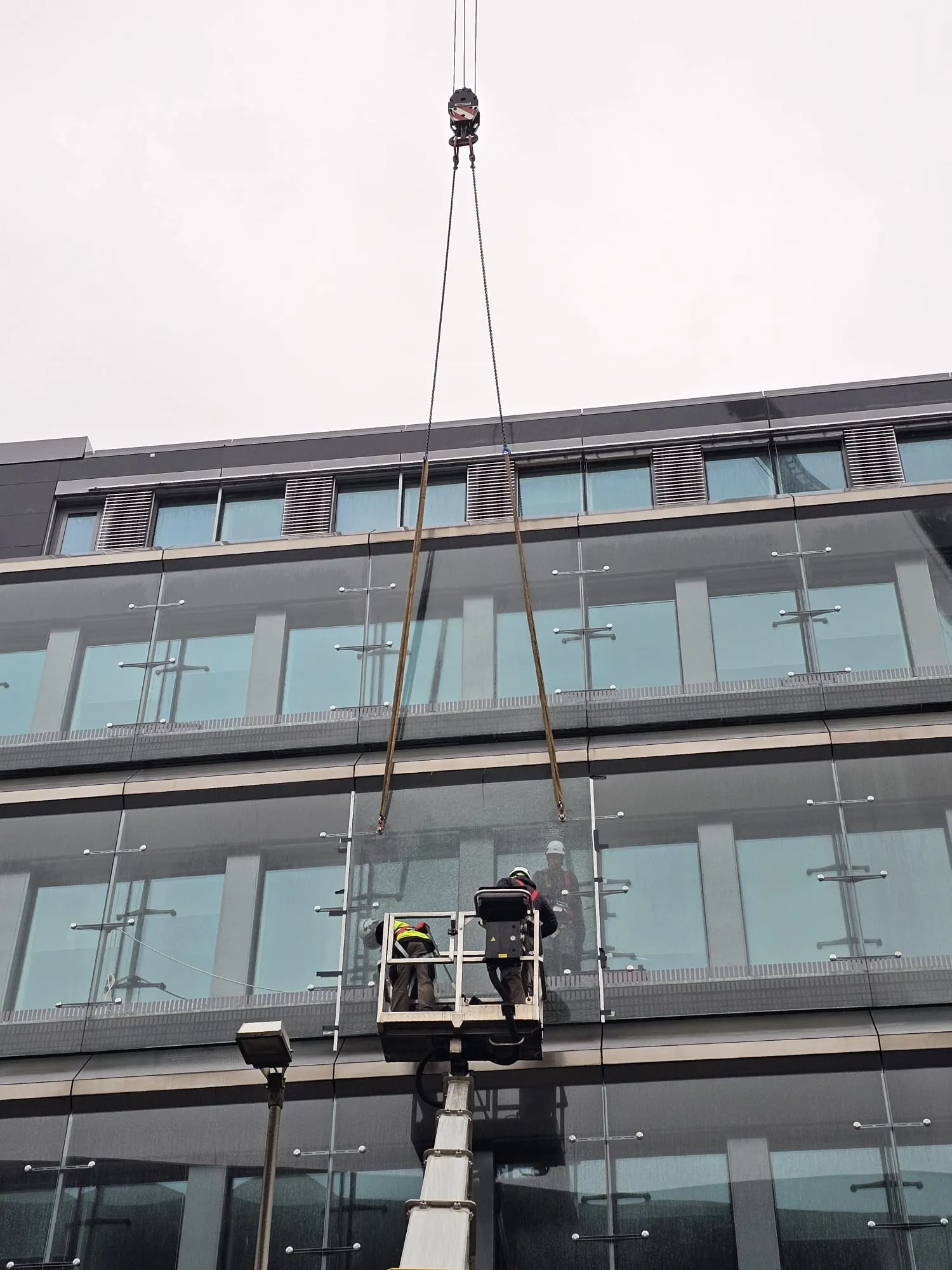 Ventouse de levage plaquant un vitrage contre une façade de bureaux — Vitralux Luxembourg