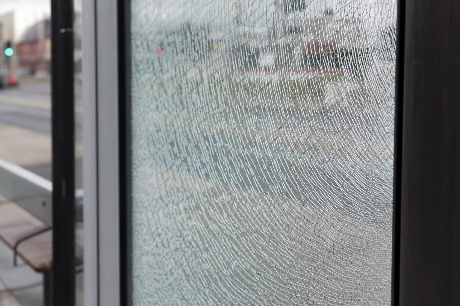 Panneau d'abri-bus en verre feuilleté fissuré mais resté solidaire après impact — sécurité du feuilleté — Vitralux Bradtke