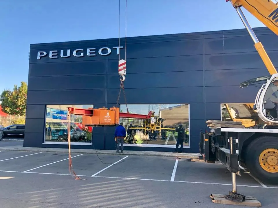 Remplacement de la vitrine d'une concession automobile à la grue au crépuscule — Vitrine de magasin Luxembourg — Vitralux Bradtke