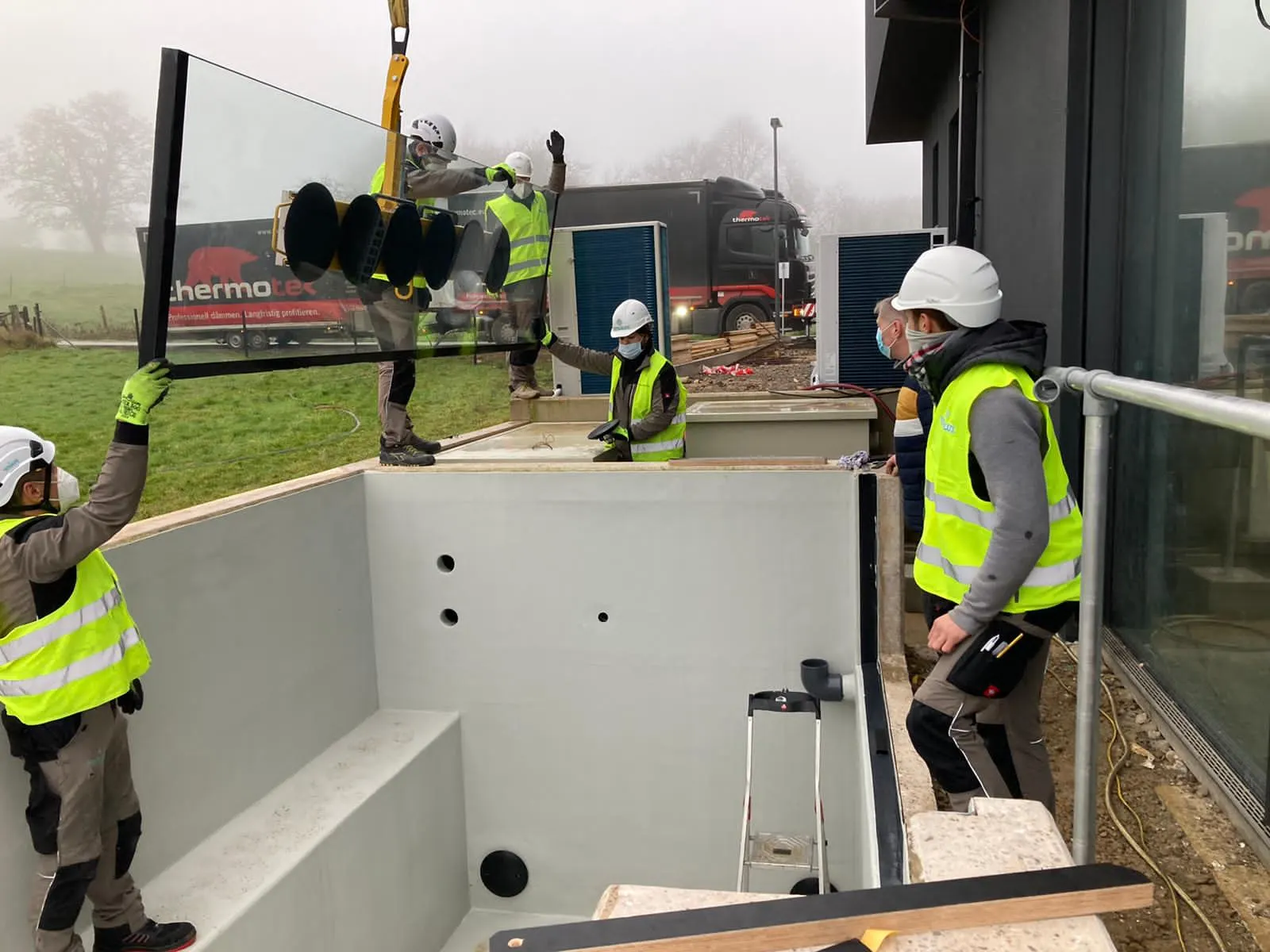 Mise en place d'un vitrage de piscine grand format à ventouses par les techniciens Vitralux — paroi piscine verre Luxembourg — Vitralux Bradtke